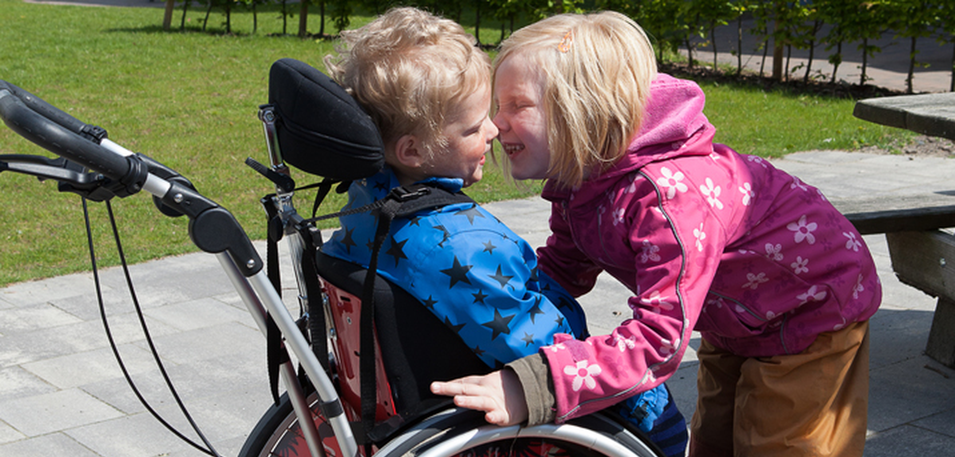 Das Bild zeigt zwei Kinder, davon eines im Rollstuhl. Foto: Kleinert / GfG
