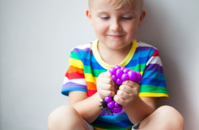 Ein Kind knetet eine Gummispielzeug.