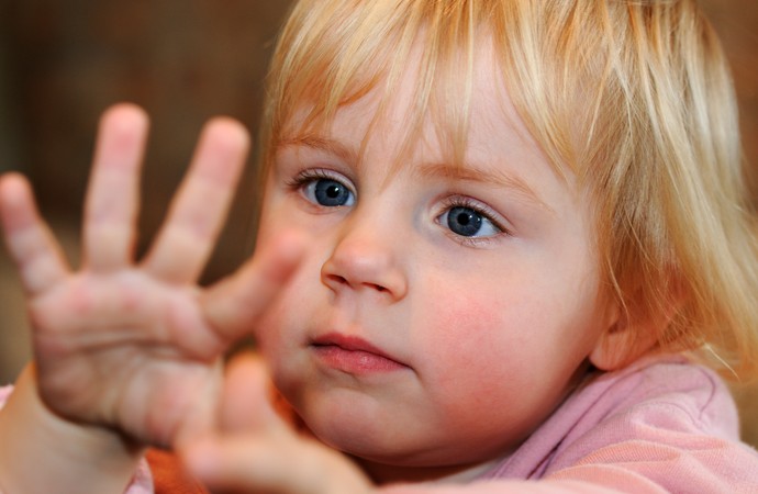 Ein Kind im Vorschulalter zeigt seine Hände.